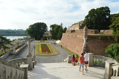 a group of people walking on a bridge next to a wall at Belle Apartments - Square 8 in Belgrade