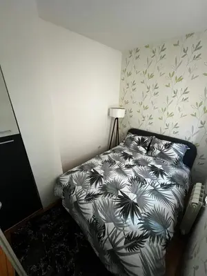 a bedroom with a bed with a black and white comforter at Biser 4 in Belgrade