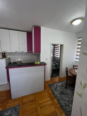 a kitchen with white and purple cabinets and a table at Biser 4 in Belgrade