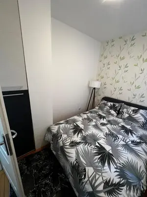 a bedroom with a bed with a black and white comforter at Biser 4 in Belgrade
