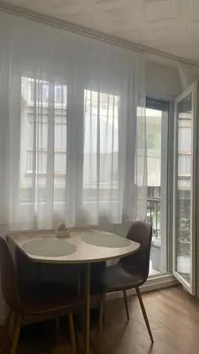 a table and chairs in a room with windows at Studio 77 in Belgrade