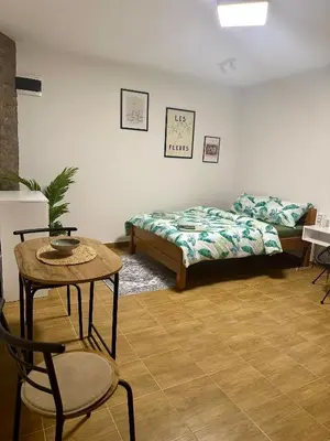 a bedroom with a bed and a table and a chair at Apartman 8 in Ruma