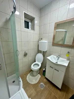 a bathroom with a toilet and a sink and a shower at Apartman 8 in Ruma