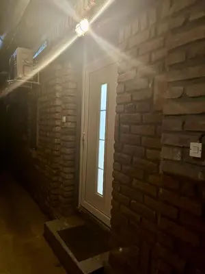 a window in a brick wall with a light at Apartman 8 in Ruma