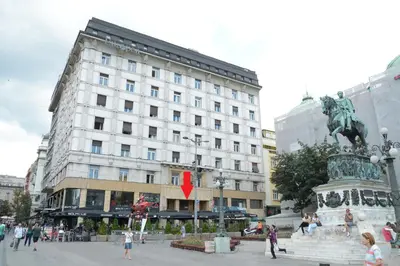 a large white building with a statue in front of it at Boutique Rooms in Belgrade
