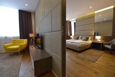 a hotel room with a bed and a yellow chair at Boutique Rooms in Belgrade