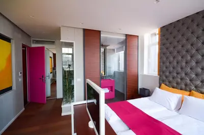 a bedroom with a large bed and a pink headboard at Boutique Rooms in Belgrade