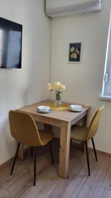 a wooden table with two chairs and a vase of flowers at Belgrade City Lux in Belgrade