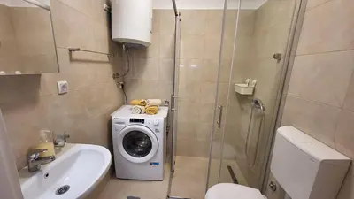 a bathroom with a washing machine next to a toilet at Belgrade City Lux in Belgrade