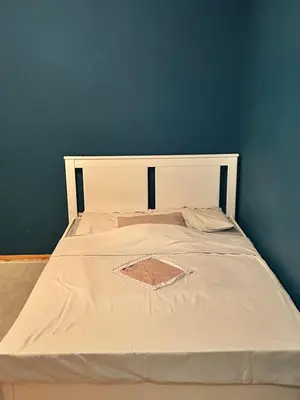 a large white bed with a blue wall at Apartman S in Belgrade