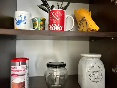 a shelf with cups and mason jars on it at Apartman S in Belgrade
