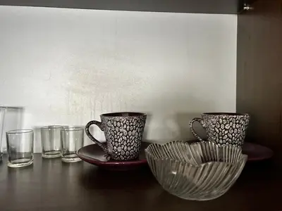two cups and a bowl on a table with glasses at Apartman S in Belgrade