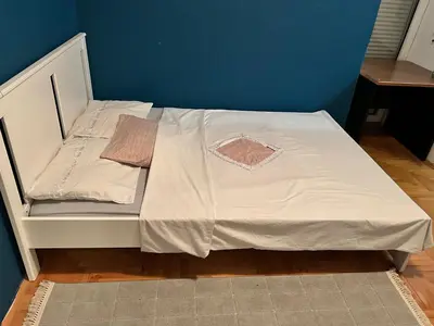 a small bed with a white sheet on it at Apartman S in Belgrade
