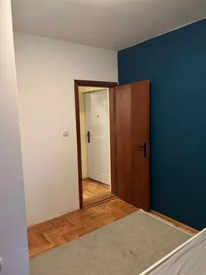 an empty room with a blue wall and a door at Apartman S in Belgrade