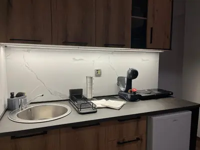 a kitchen counter with a sink and a phone on it at Liberte Apartments Voždovac in Belgrade
