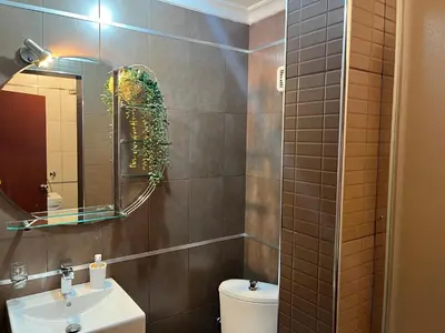 a bathroom with a sink and a mirror and a toilet at Liberte Apartments Voždovac in Belgrade