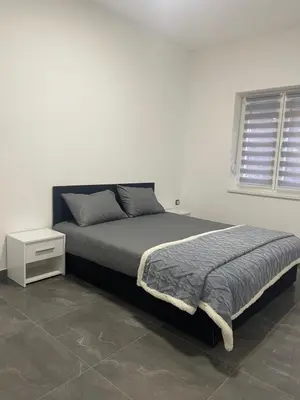 a bedroom with a bed and a white wall at Vila Mila Ćirić in Pančevo