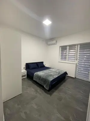 a bedroom with a blue bed in a white room at Vila Mila Ćirić in Pančevo