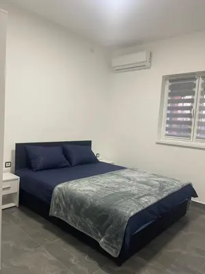 a bedroom with a blue bed and a window at Vila Mila Ćirić in Pančevo