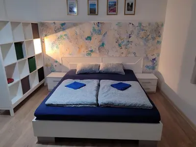a bedroom with a bed with blue pillows on it at Apartman Centar Surcin in Surčin