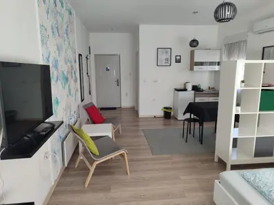 a living room with a couch and a dining room at Apartman Centar Surcin in Surčin