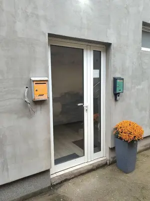a glass door of a building with a plant next to it at Apartman Centar Surcin in Surčin