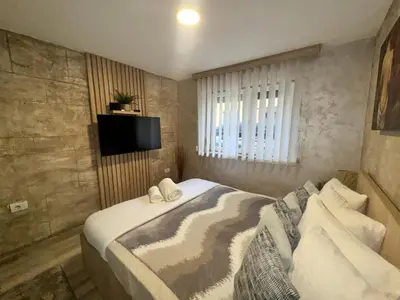 a bedroom with a bed with a television on the wall at Entire Place In Zemun in Belgrade