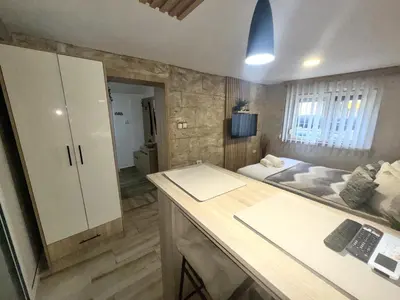 a room with a desk and a bed in the background at Entire Place In Zemun in Belgrade