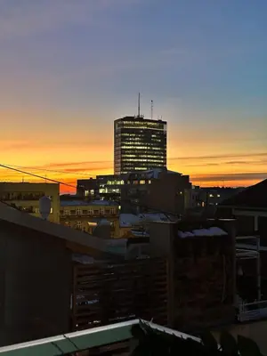 a city skyline at sunset with a tall building at Sky Rooftop 100 sqm Big Apartment in Belgrade