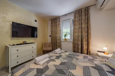 a bedroom with a bed with a tv and a dresser at Kapetan apartman in Belgrade