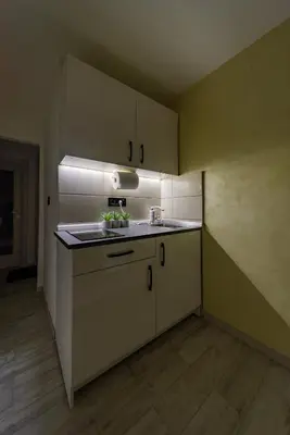 a kitchen with white cabinets and a sink at Kapetan apartman in Belgrade