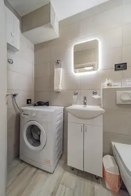 a bathroom with a washing machine and a sink at Kapetan apartman in Belgrade