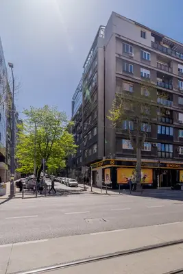 an empty city street with a tall building at Kapetan apartman in Belgrade