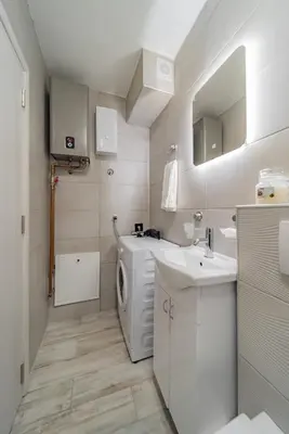 a bathroom with a washing machine and a sink at Kapetan apartman in Belgrade