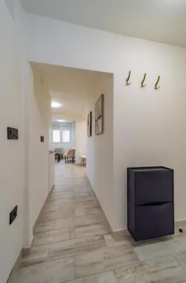 a hallway with white walls and a black cabinet at Kapetan apartman in Belgrade