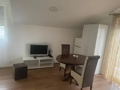 a living room with a table and a television at Apartmani Amon in Meljak