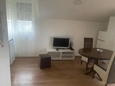 a small living room with a table and a television at Apartmani Amon in Meljak