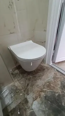 a white toilet sitting in a bathroom next to a window at White Apartment Slavija in Belgrade