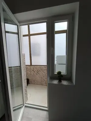 a room with two windows and a bathroom with a tub at White Apartment Slavija in Belgrade
