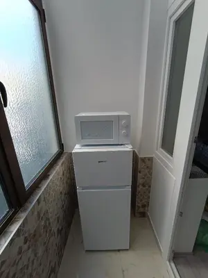 a microwave sitting on top of a refrigerator at White Apartment Slavija in Belgrade