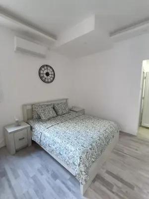 a bedroom with a bed and a clock on the wall at White Apartment Slavija in Belgrade