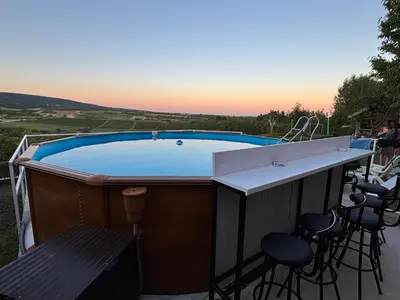 a hot tub on a patio with a table and chairs at Hopovske Terase in Irig