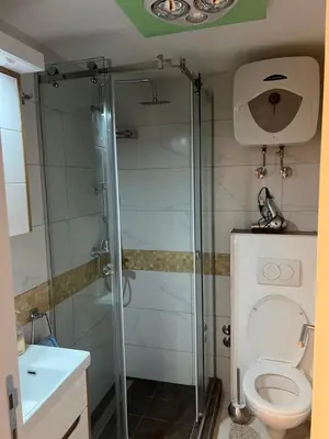 a bathroom with a shower with a toilet and a sink at Fontana in Belgrade