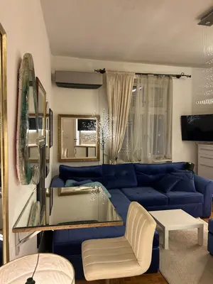 a living room with a blue couch and a table at Lux Beba Pancevo in Pančevo