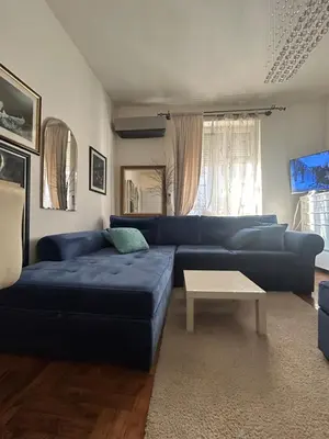 a living room with a blue couch and a table at Lux Beba Pancevo in Pančevo