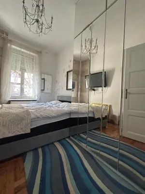 a bedroom with a large bed and a mirror at Lux Beba Pancevo in Pančevo