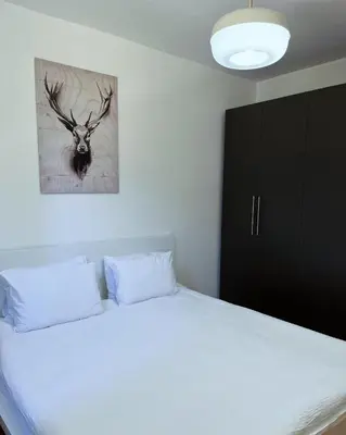 a bedroom with a bed with a deer head on the wall at BW Eterna Apartment in Sajmište