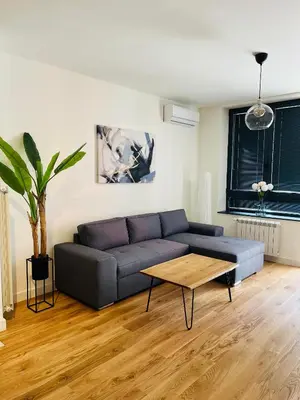 a living room with a blue couch and a table at BW Eterna Apartment in Sajmište