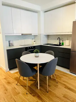 a kitchen with a white table and chairs at BW Eterna Apartment in Sajmište