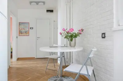 a table with a vase of pink flowers in a room at Gajba Apartment in Belgrade